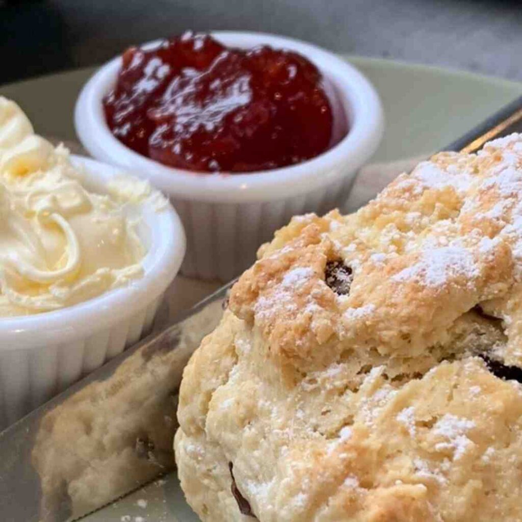 Fruit scone with pots of strawberry jam and clotted cream